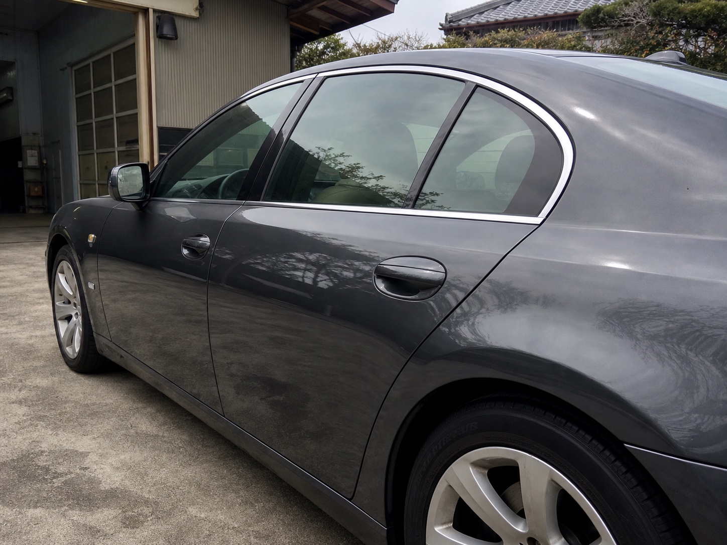 映り込みが弱く軽くくすんだ濃いグレーの車